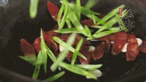 先后下香腸片、四季豆絲均勻翻炒，加適量清水燜煮一下。