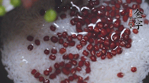 將炒好的食材和大米、紅豆一起放進(jìn)電飯鍋煮。