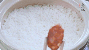 煮開后轉(zhuǎn)小火，當米飯出現(xiàn)小孔時，鋪上金字麻辣香腸。