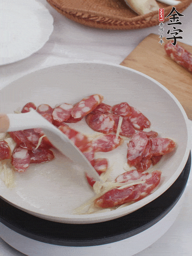 油溫3成熱時(shí)，下姜絲、蒜片、香腸炒出油脂。