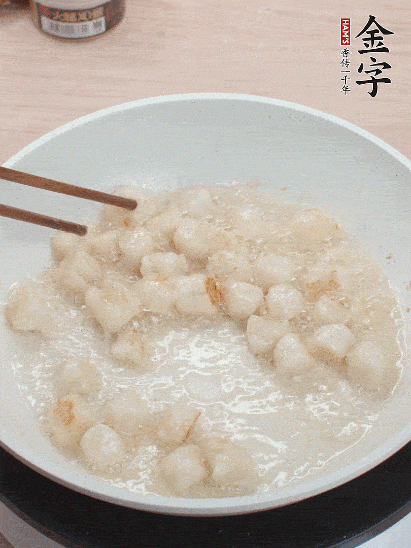 油溫4成熱，鮮貝蘸干淀粉下鍋煎，一面微黃后翻面。