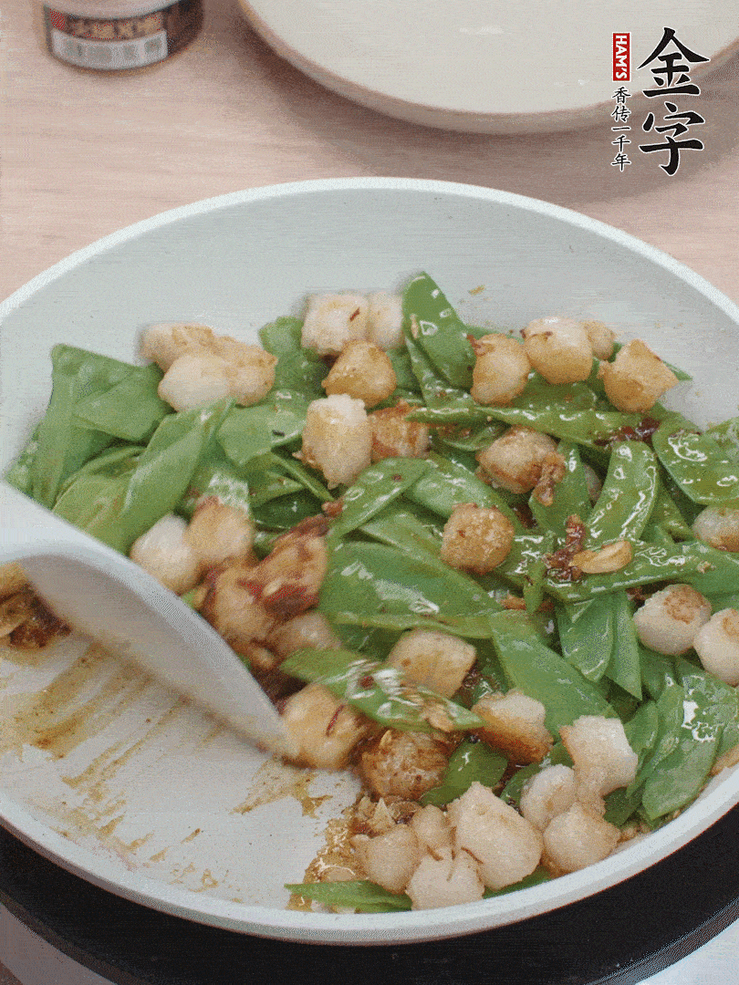 下甜豆莢、鮮貝輕輕翻炒均勻。