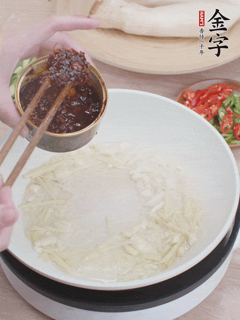 起鍋熱油，姜蒜、金字火腿干貝醬煸香。