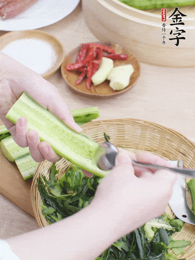 黃瓜削皮，對(duì)半切開，勺子挖去內(nèi)瓤，斜刀切片。青蒜斜刀切段。