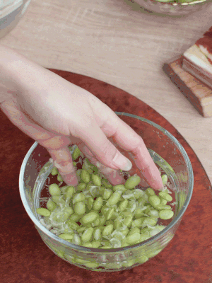 青豆剝殼，搓去外衣。