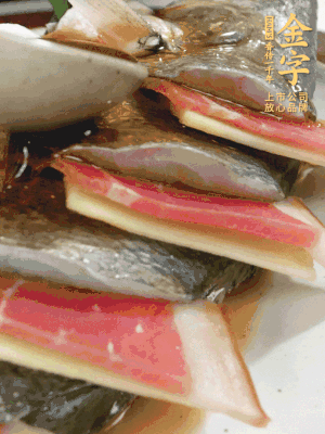 魚肚中塞蔥結(jié)、火腿片，魚身上碼放姜片、火腿片，倒入混合的料汁。
