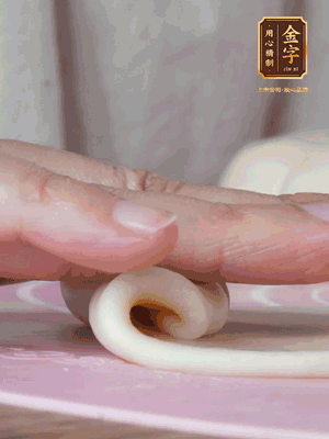 做面劑 油皮按扁，中間包入一個油酥，邊緣收緊捏死。包好的面劑按扁，用搟面杖搟壓成橢圓形。從底部向上卷成筒狀，用保鮮膜蓋好松弛15分鐘，再把筒狀縱向搟壓成長條狀。再卷一次，松弛20分鐘