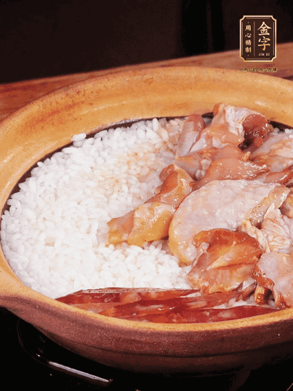 煮到椰子水微微收干轉(zhuǎn)小火，快速均勻鋪上雞肉、金字香腸